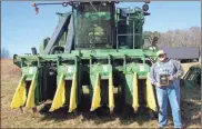  ?? / Kevin Myrick ?? Justin Womack, the Young Farmer of the Year for 2018, stands with one of two harvesters his family uses on their farm in the Cedartown area. He continues on a tradition of row cropping corn, cotton and soybeans.