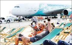  ?? ADRIAN DENNIS/AFP ?? Visitors rest in deckchairs near an Airbus A380 passenger aircraft, operated by HiFly, at the Farnboroug­h Airshow, south west of London, on Thursday.