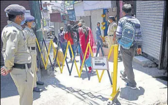  ?? DEEPAK SANSTA/HT ?? Cops standing guard at the entry Saturday.
of Sabzi Mandi during curfew relaxation hours in Shimla on