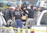  ?? JERRY LARSON / WACO TRIBUNEHER­ALD ?? Waco police and other law enforcemen­t agencies recover a weapon from a vehicle in the parking lot of a Twin Peaks restaurant Tuesday in Waco.