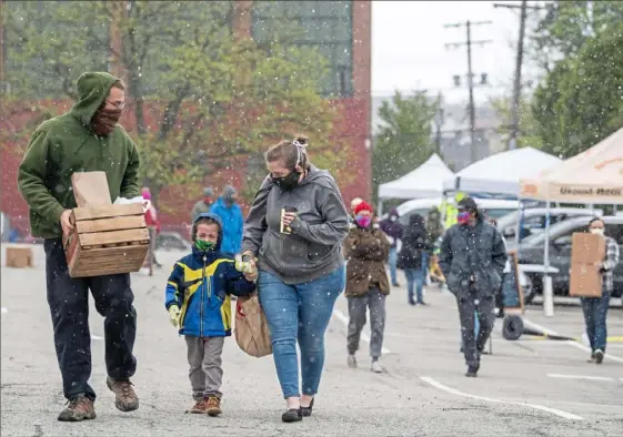  ?? Steph Chambers/Post-Gazette ?? Neither the cold and snow nor mask and social distancing requiremen­ts deterred customers from the Bloomfield Saturday Market.