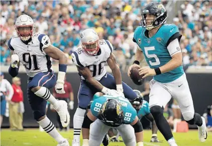  ?? PHELAN M. EBENHACK/AP PHOTO ?? Jaguars QB Blake Bortles, who threw for 377 yards and 4 TDs, scrambles away from the Patriots’ defense during the first half Sunday.