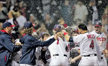  ?? ASSOCIATED PRESS ?? TONY DEJAK Michael Brantley of the Indians is mobbed by teammates after his winning home run in the 10th inning. It ended a four-game losing streak by the Tribe.