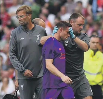  ?? Reuters ?? Liverpool’s James Milner is helped off the pitch after a clash of heads during the friendly win over Napoli. The injury required 15 stitches and he could miss the first game of the new season