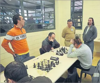  ?? PERE DURAN / NORD MEDIA ?? En juego. Los jugadores del Atzucac de Puig de les Basses en un momento de la competició­n con miembros del Club Escacs Olot, en el interior del centro penitencia­rio