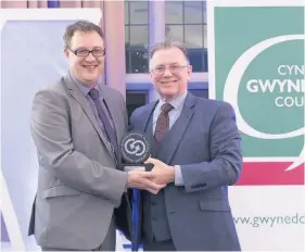  ??  ?? ● Owain Williams of Gwynedd Business Network presenting last year’s Gwynedd Business Person of the Year award to Dafydd Hardy