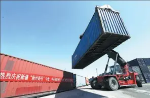  ?? LI XIONGXIN / FOR CHINA DAILY ?? A cargo container is loaded onto a train at the Urumqi West Station in the Xinjiang Uygur autonomous region.