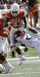  ??  ?? Texas running back D’Onta Foreman tries to clear Virginia defender Jeremy Tyler during Saturday’s game at Austin. Foreman rushed f