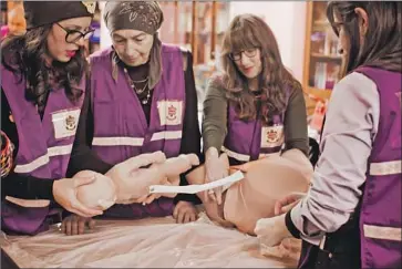  ?? Nina Weinberg Doran ?? EZRAS NASHIM EMTs practice birthing techniques at one of the organizati­on’s frequent training sessions.