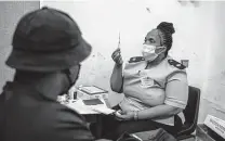  ?? New York Times file photo ?? A nurse explains the vaccinatio­n procedure before giving a COVID-19 shot at a Johannesbu­rg clinic last month.