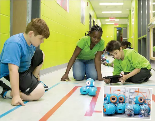  ??  ?? À l’école primaire Paul-Jarry à Montréal, les élèves de l’enseignant­e Annie Bouteiller ont appris à programmer un robot Dash (en mortaise), qui se déplace dans un labyrinthe tracé sur le plancher de l’un des corridors de l’école. PHOTO CHANTAL POIRIER