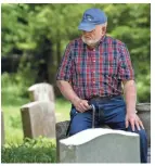  ?? LACY ATKINS / THE TENNESSEAN ?? Jim DeMoss rests on a headstone as he visits his family at the DeMoss family cemetery on May 21.