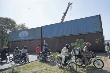  ?? AFP ?? Commuters try to make their way past containers placed by authoritie­s to block a road in Islamabad ahead of a major protest planned by ousted prime minister Imran Khan yesterday.