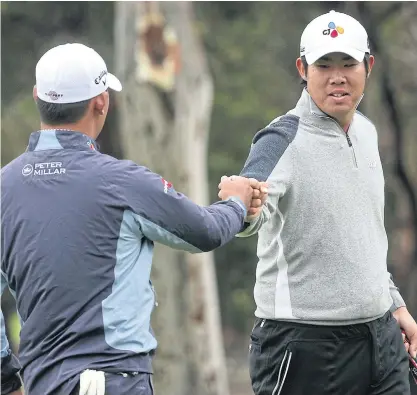  ??  ?? South Korea’s An Byeong-Hun, right, and Kim Si-Woo celebrate on the 11th hole during the second round.