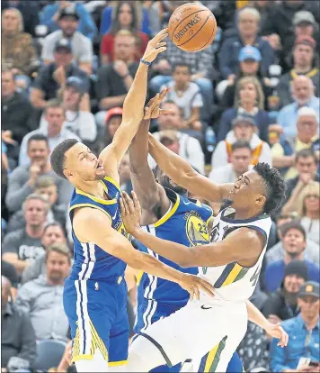  ?? RICK BOWMER — THE ASSOCIATED PRESS ?? Golden State’s Stephen Curry swats away a shot attempt of Utah’s Donovan Mitchell on Friday night.