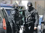  ?? AP/CLAUDE PARIS ?? Police officers patrol outside a building during searches Tuesday in Marseille, southern France.