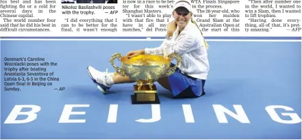  ?? — AP ?? Denmark’s Caroline Wozniacki poses with the trophy after beating Anastasija Sevastova of Latvia 6- 3, 6- 3 in the China Open final in Beijing on Sunday.