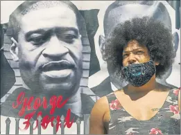  ?? DAMIAN DOVARGANES — THE ASSOCIATED PRESS ?? Actor Steven Thompson next to a poster of George Floyd in Los Angeles on Friday. Thompson is choosing not to watch the televised trial of Derek Chauvin, the white police officer charged in the death of George Floyd.