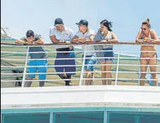  ?? AFP ?? Tourists stranded over coronaviru­s fears peak from inside the Monarch cruise at the port of Colon in Panama City.