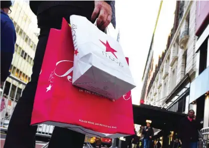  ??  ?? NEW YORK: Shoppers are seen outside Macy’s Herald Square in midtown Manhattan in New York. Retail executives are having a lackluster outlook on holiday shopping with the warm weather that has depressed sales of cold-weather apparel; a drop in...