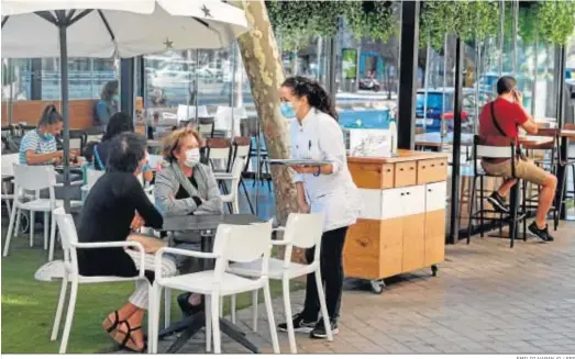  ?? EMILIO NARANJO / EFE ?? Una camarera atiende a dos clientas en un bar.