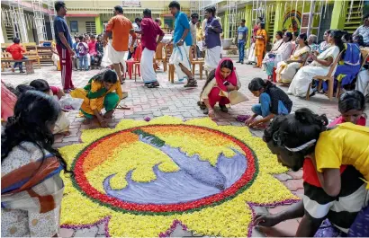  ?? PTI ?? Women make a ‘rangoli’ as they celebrate ‘Onam’ at a flood relief camp in Kochi on Saturday. —