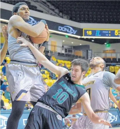  ?? KARL MERTON FERRON/BALTIMORE SUN ?? Towson forward Alex Thomas secures a rebound in front of Loyola Maryland guard Andrew Kostecka as the Tigers won their seventh straight game over a Baltimore-area school, defeating the Greyhounds, 70-53, on Wednesday at SECU Arena. COVERAGE, PG 5