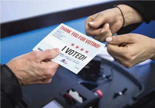  ?? ASHLEE REZIN/SUN-TIMES ?? A Lincoln Park woman receives her “I Voted!” sticker after early voting in the Feb. 28 municipal election at the Lincoln Park Branch Library.