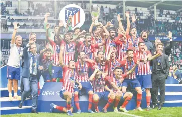  ?? — AFP photo ?? Atletico Madrid’s players celebrate with the trophy after winning the UEFA Super Cup match against Real Madrid at the Lillekula Stadium in Tallinn, Estonia.