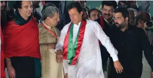  ?? AP ?? Imran khan arrives to address the rally in Lahore as PtI workers look on. —