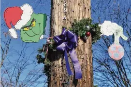  ?? Ned Gerard/Hearst Connecticu­t Media ?? Purple ribbons have been added to the holiday decoration­s that adorn many of the street signs and utility poles in Milford, Dec. 21, 2022. The ribbons, symbolizin­g domestic violence awareness, have been put up in memory Julie Minogue, who was killed in her Milford home on Dec. 6.
