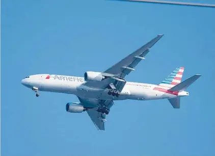  ?? WILFREDO LEE/AP ?? An American Airlines Boeing 777 prepares to land Wednesday at Miami Internatio­nal Airport. The airline said Thursday that it lost $2.2 billion in the fourth quarter, with revenue plunging by nearly two-thirds from a year earlier.