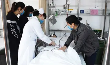  ?? — AFP photo ?? A member of the medical staff (left) takes care of an injured person after a hijacked bus crashed into pedestrian­s in Longyan in China’s eastern Fujian province.