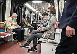  ?? MICHEL EULER / AP ?? People wearing face masks to protect against COVID-19 ride a subway in Paris on Thursday.