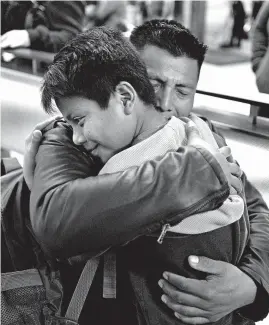  ?? RINGO H.W. CHIU/AP ?? David Xol, of Guatemala, hugs his son Byron last week at Los Angeles Internatio­nal Airport as they reunite after being separated at the border in May 2018. “He grew a lot,” Xol said.