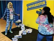  ?? RODNEY HO/RHO@AJC.COM ?? Actors Ace Marrero and Kymberli Dee participat­e in the “Save the Video Store” interactiv­e experience at The Avenue West Cobb, loosely playing Garth and Wayne from “Wayne’s World.”