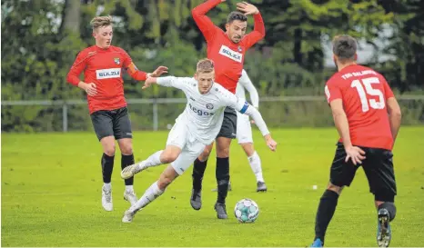  ?? FOTO: THOMAS WARNACK ?? Ostrachs Kapitän Andreas Zimmermann (weißes Trikot) gegen drei Balinger: Tim Göttler, Heiko Belser und Adrian Müller (v.l.).