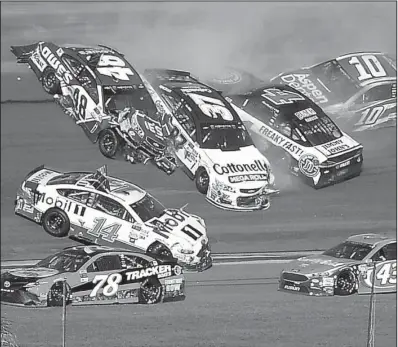  ?? AP/PHELAN M. EBENHACK ?? An accident takes out Jimmie Johnson (48), Clint Bowyer (14), Chris Buescher (37), Kevin Harvick (4) and Danica Patrick (10) between Turns 3 and 4 on the 128th lap of the Daytona 500 as Martin Truex Jr. (78) and Aric Almirola (43) drive past the wreck.