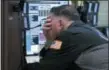  ?? RICHARD DREW — THE ASSOCIATED PRESS ?? Trader Jonathan Mueller works Friday in his booth on the floor of the New York Stock Exchange.