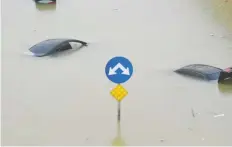  ?? AFP ?? RIYADH: Vehicles are seen submerged in water on a flooded highway in western Riyadh following heavy rainfall across most of Saudi Arabia yesterday.—