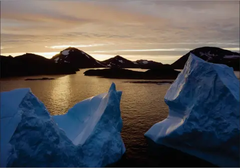  ?? AP FELIPE DANA ?? An aerial view of large Icebergs floating as the sun rises near Kulusuk, Greenland, early Friday, Aug. 16. Greenland has been melting faster in the last decade and this summer, it has seen two of the biggest melts on record since 2012.