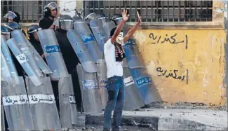  ?? Photo: REUTERS ?? Appeal for calm: A protester tries to stop other protesters hurling stones at police during clashes in Alexandria today.