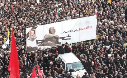  ?? Picture: EPA-EFE ?? IN MOURNING. Iranians carry a huge banner with poster of slain Iranian Revolution­ary Guards Corps, Qasem Soleimani, and slogans reading in Persian ‘hard revenge is on the way’ in Tehran, Iran, yesterday.