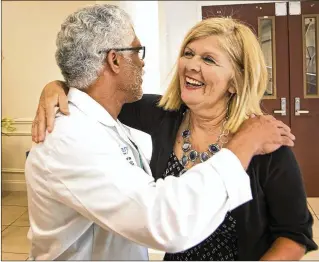  ?? LANNIS WATERS PHOTOS / THE PALM BEACH POST ?? Suzanne, who was stabbed near the Royal Park Bridge last month, hugs Dr. Robert Borrego, one of her surgeons at St. Mary’s Medical Center, on Wednesday.