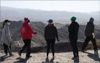  ?? Gilbert Bernall/The Signal ?? From left, Christina Park, Chrissy Ball, Marissa Hull, Brianne Silva, and Russell Ball look out over the hills behind Sand Canyon Road as they plan where to search for Casey, a Queensland heeler that was lost during the Tick Fire that burned down the Corrales/Hull family home, in Canyon Country on Wednesday.