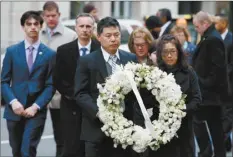  ?? AP photo ?? The father of Lingzi Lu, Jun Lu, and her aunt Helen Zhao, carry a wreath ahead of the family of Martin Richard, Henry, Bill, Denise and Jane (partially hidden), during a ceremony Sunday at the site where Martin Richard and Lingzi Lu were killed in the...