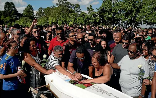  ??  ?? Friends and relatives grieve during the burial of young soccer player Arthur Vinicius, one of the victims of a fire at a Brazilian soccer academy, in Volta Redonda.