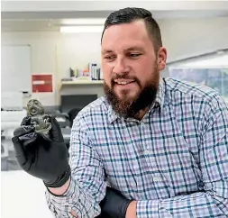  ??  ?? Corban Te Aika, curator of human history at Canterbury Museum, holding Te Aika hei tiki, a prized taonga of Nga¯ i Tahu and the Te Aika family.