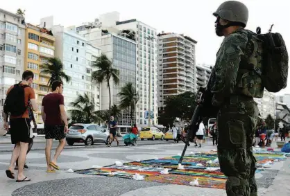  ?? Tomaz Silva/Agência O Globo ?? Militar faz segurança na praia de Copacabana (zona sul do Rio), ontem; mais de 10 mil agentes federais de segurança atuarão no Estado até o final deste ano para combater a violência; tropas iniciaram bloqueios