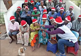  ?? (AP Photo/Mahesh Kumar A.) ?? George Rakesh Babu, right, founder of Good Samaritans India, a non-government organizati­on, feeds food to a homeless person at a shelter to celebrate Christmas Friday on the outskirts of Hyderabad, India.